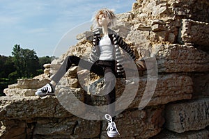 Ball-jointed doll emo sitting on the limestone photo