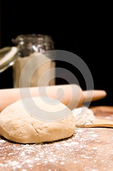 Ball of kneaded dough, rolling pin with scattered flour