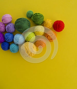 Ball for knit rainbow color a yellow background.