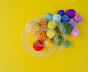 Ball for knit rainbow color a yellow background.