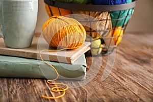 Ball of knitting yarn with cup and books on table