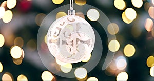 Ball, new year and Christmas with festive lights hanging on tree with bokeh background. Closeup of ornament, decoration
