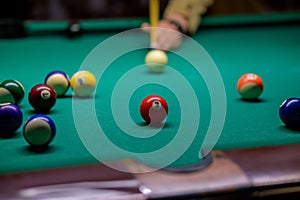 The ball with number 3 at which the cue ball is aiming. a man plays billiards in a bar. snooker