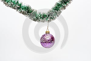 Ball with ornaments hang on shimmering green tinsel. Decoration for Christmas tree hang on tinsel. Christmas decorations