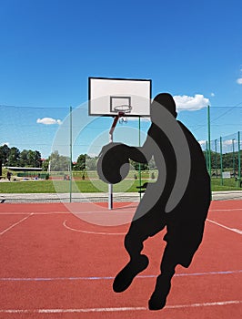 The ball in the player`s hands flies into the basketball ring on a sunny and clear day. Contour image of a basketball player. Mult