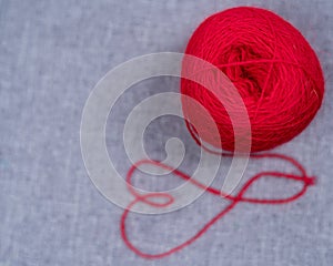 A ball of red thread on a black background.