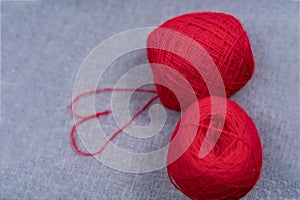 A ball of red thread on a black background.