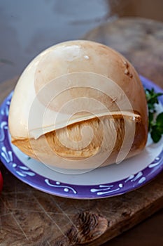 Ball of smoked Italian soft cheese Mozzarella di Bufala Campana served with fresh green basil and red sicilian tomatoes