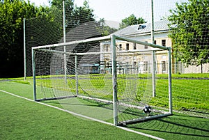 A ball in a soccer goal on an amateur soccer field on a sunny summer day
