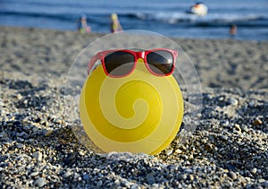 Ball in sunglasses on summer beach