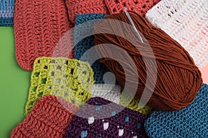 Ball of thread and a crochet hook. Crochet hook and thread on the background of knitted patterns.