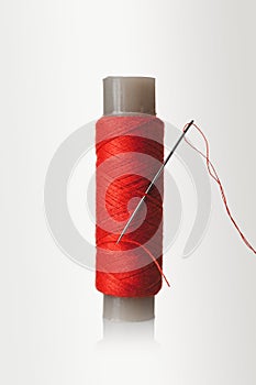 ball of thread, spool of sewing thread and needle isolated on white background