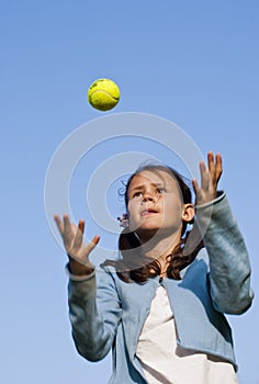 Young girl throwing tennis ball