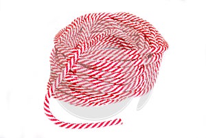 A ball of white-red rope lies on a white background. A coil of rope.