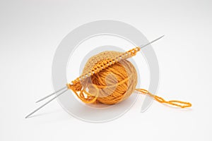 Ball of woolen thread for knitting orange color and knitting needles