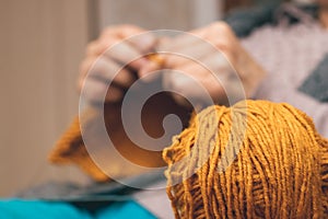 A ball of yarn for knitting near a woman who knits a sweater