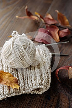 Ball of yarn and knitting on a wood table
