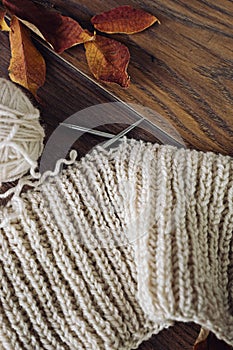 Ball of yarn and knitting on a wood table