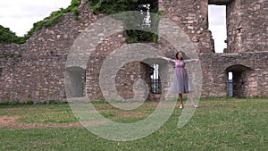 Ballerina dancing in nature near the ruins of an ancient castle