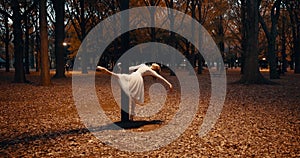 Ballerina, dancing and night for outdoor performance at street light or flexibility, practice or creative. Female person