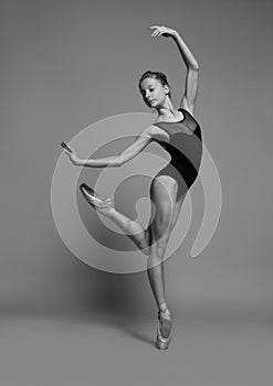 Ballerina dancing in pointe shoes and black leotard