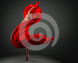 Ballerina dancing with Red Silk Fabric flying on Wind. Modern Ballet Dancer jumping over Dark Studio background. Fashion Woman in