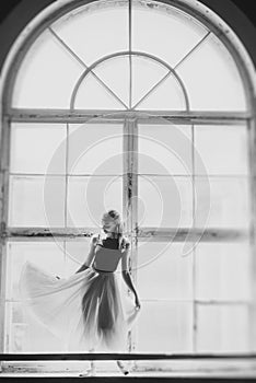 Ballerina dancing at window sill background