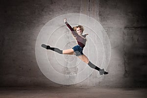 Ballerina in a jump on a gray background