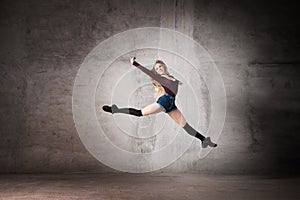 Ballerina in a jump on a gray background