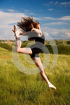 Ballerina jumping in a field