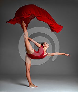 Ballerina Jumping in Pointe Shoes with Flying Red Cloth, Modern Ballet Dance,  Gray Background