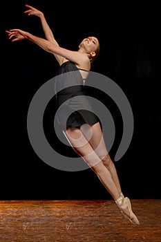 Ballerina Leaping in Studio on Black Background