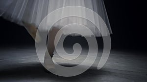 Ballerina legs dancing on tiptoe. Ballet dancer feet performing in pointe shoes.