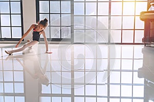 Ballerina little girl wear black ballet dancing in studio. Lovely kid girl pose dance ballet at indoor with reflections