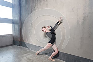 Ballerina movement in classic ballet posing near window