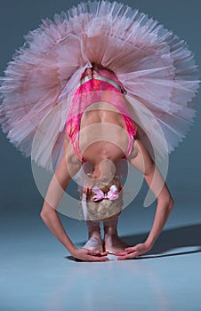 Ballerina in pink tutu leaning forward