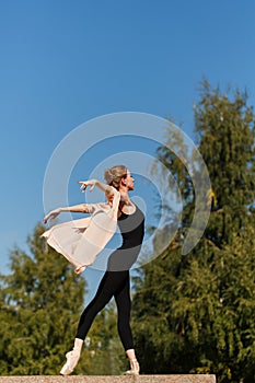 Ballerina in pointe dancing in street.