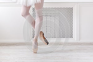 Ballerina in pointe shoes, graceful legs, ballet background