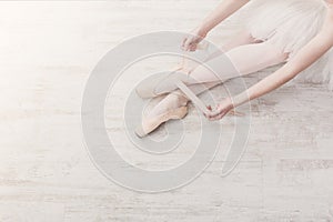 Ballerina puts on pointe ballet shoes, graceful legs