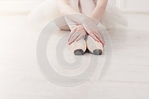 Ballerina puts on pointe ballet shoes, graceful legs