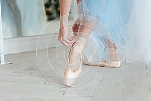 Ballerina puts pointe shoes