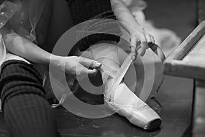 Ballerina puts on pointe shoes