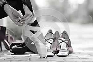 Ballerina Putting Pointe Ballet Shoes on her Feet