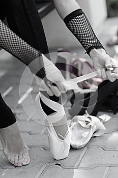 Ballerina Putting Pointe Ballet Shoes on her Feet