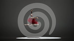 A ballerina in a red tutu and pointe shoes during a twine jump. A young woman dancing elements of classical ballet in a