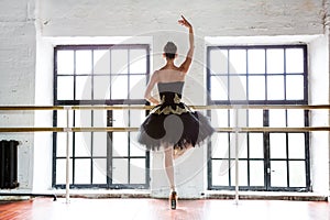 Ballerina rehearsal in the hall. Ballet machine. White walls, wooden floors, large windows