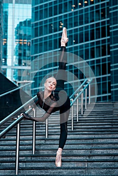 Ballerina`s show stretching on steps in sportswear.
