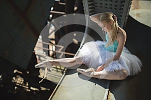 Ballerina sitting on the edge of bridge