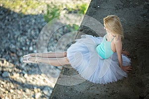 Ballerina sitting on the edge of bridge