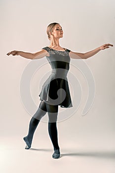 a ballerina stands in a pa on a white background